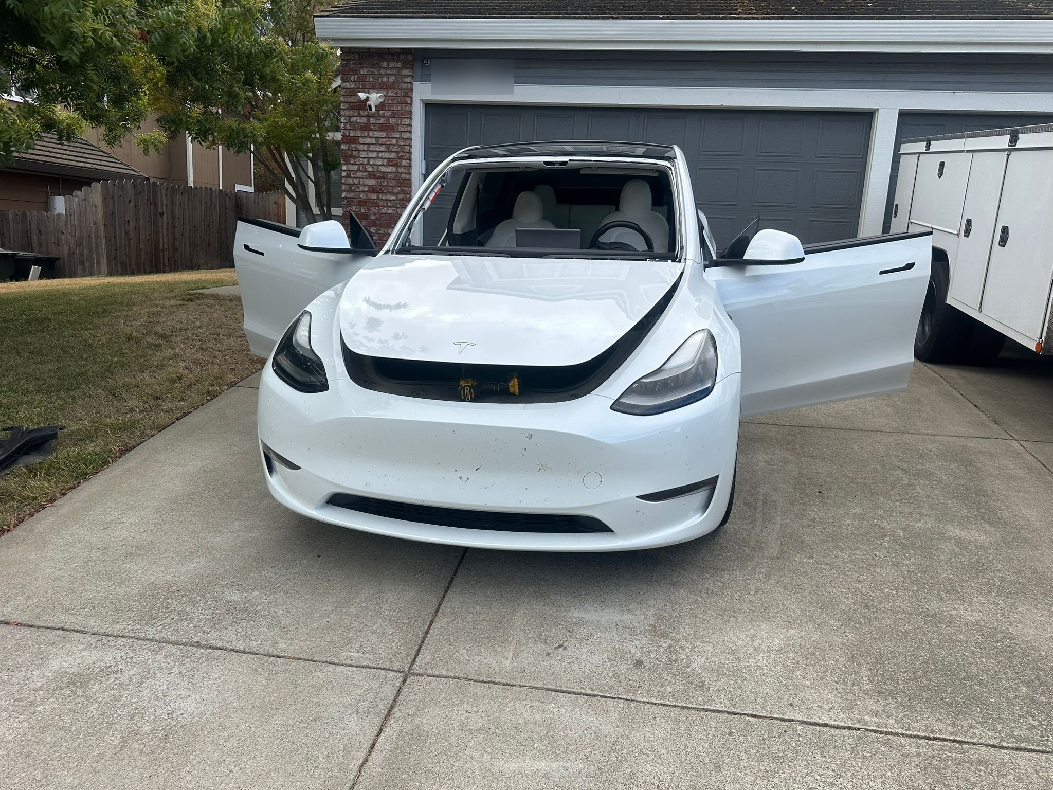White Tesla Model Y in driveway during mobile windshield replacement service by Auto Glass of Scottsdale